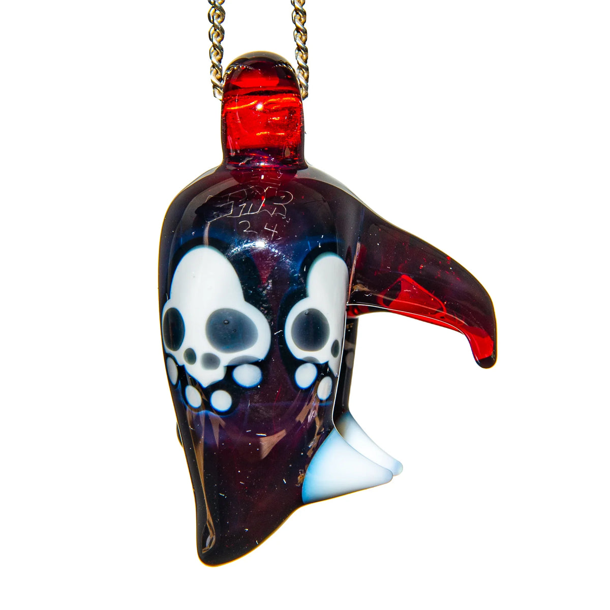Hand-blown glass pendant with red and black coloring and skull designs, hanging on chain