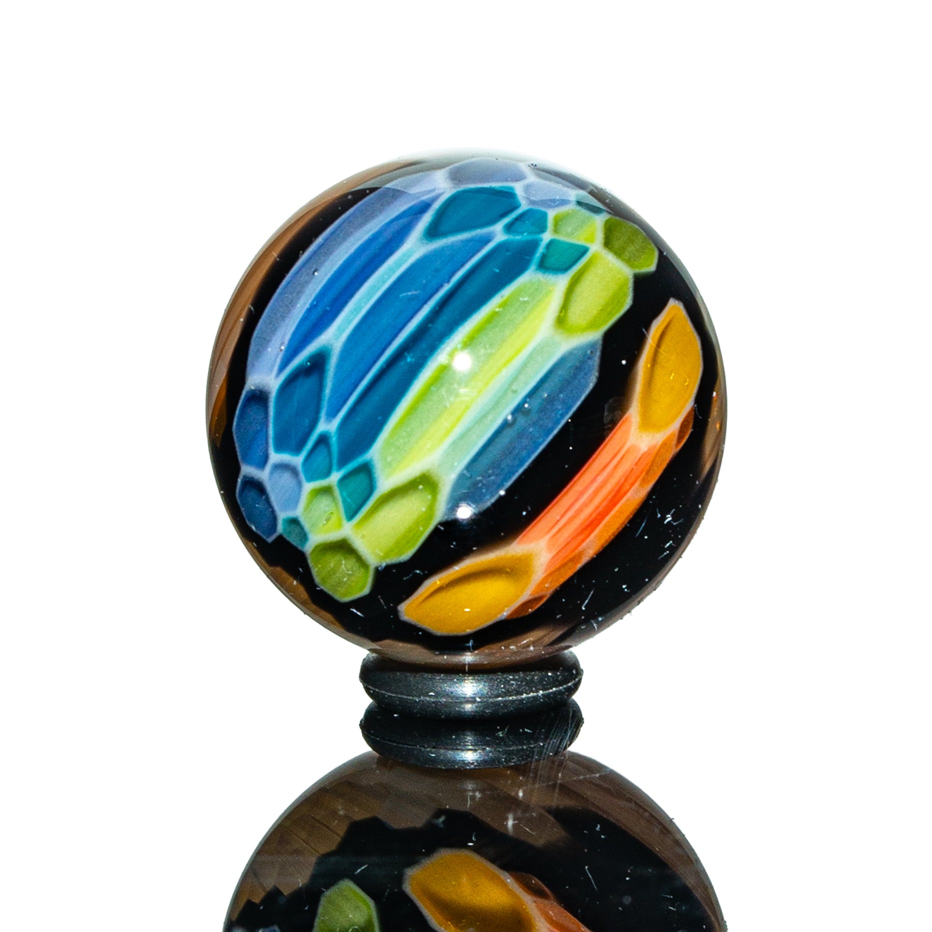 Colorful heady glass marble with blue, green, and orange patterns on a black background