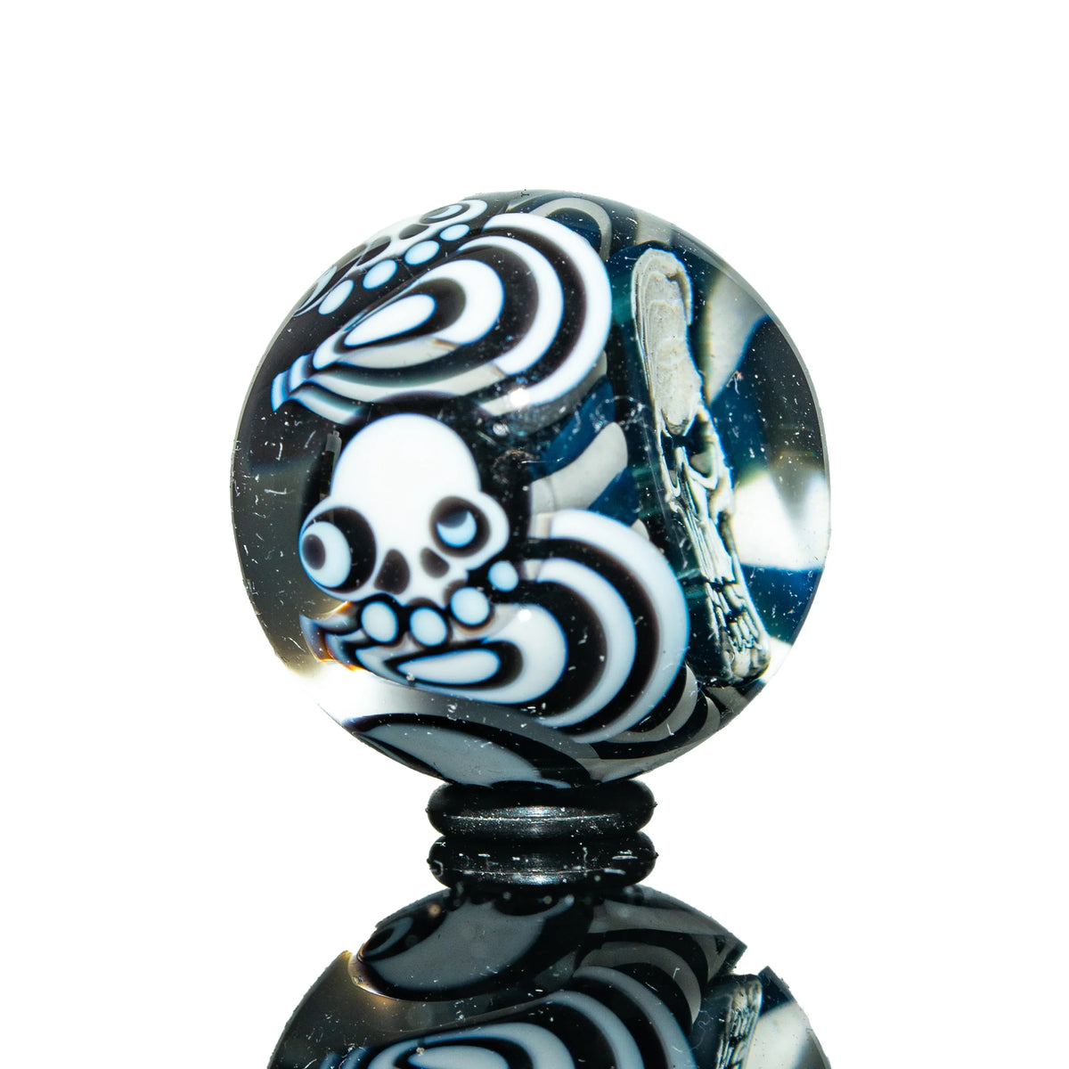 Handcrafted glass marble with intricate white and black octopus and skull designs