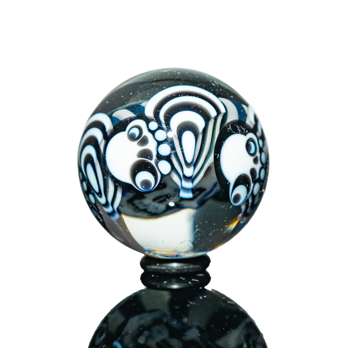 Glass marble with black and white psychedelic patterns, detailed dot and wave designs