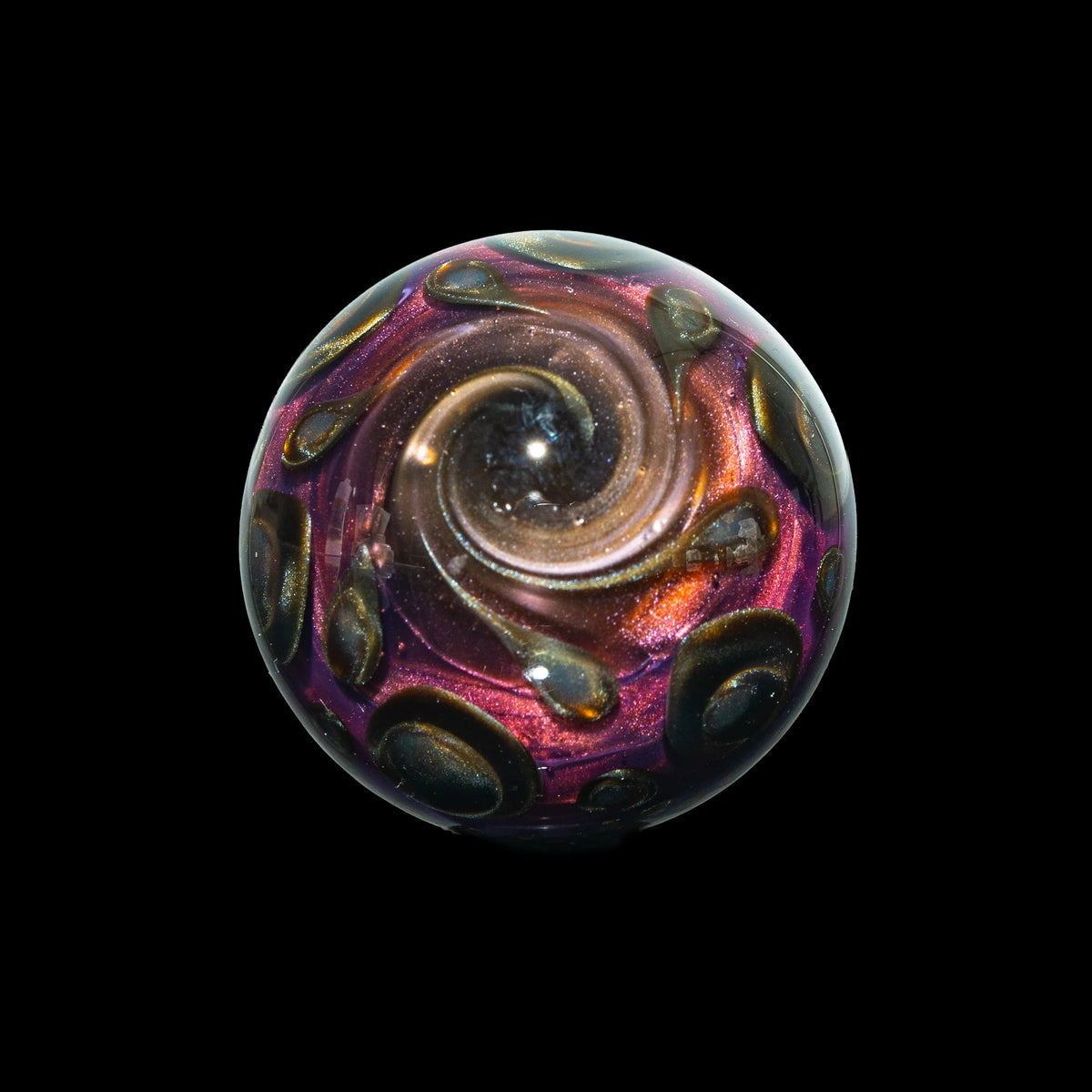 Handcrafted glass marble with metallic swirl and iridescent galaxy design on black background