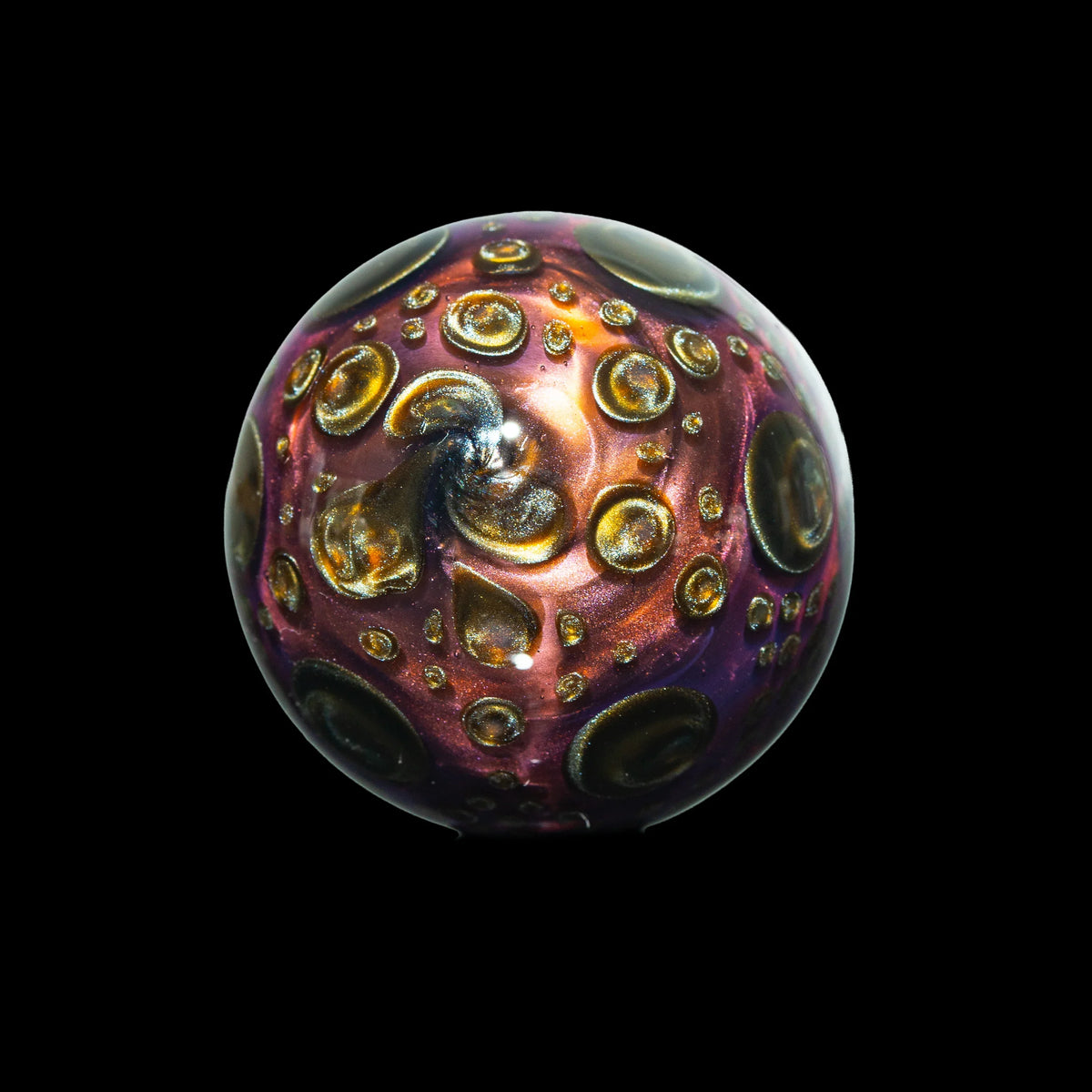Handcrafted glass marble with metallic swirls and raised bubble details on black background