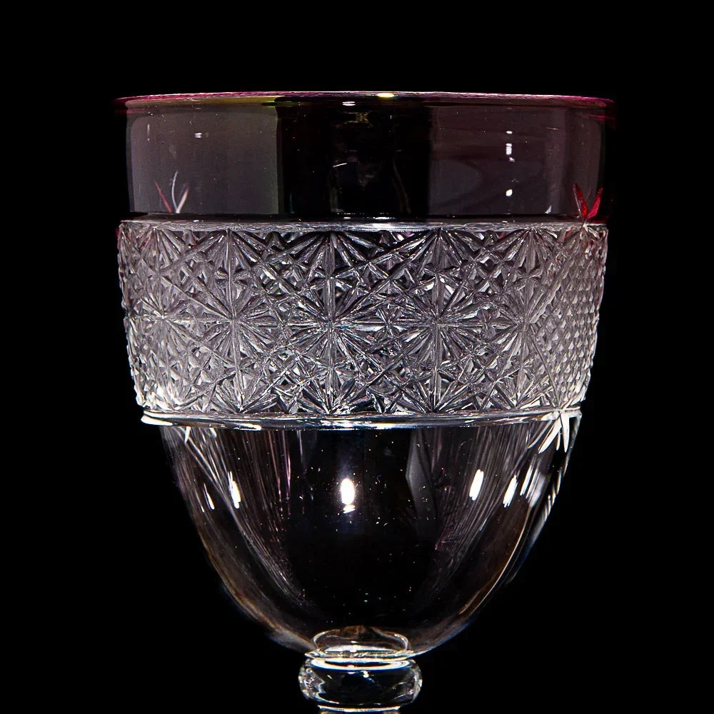 Clear glass piece with intricate geometric etching on a dark background