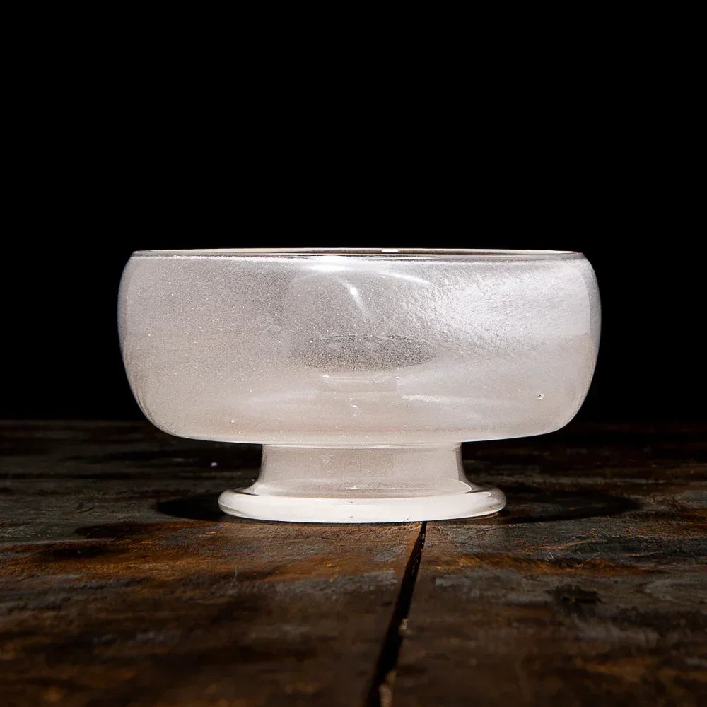 Frosted glass bowl accessory on wooden surface with black background