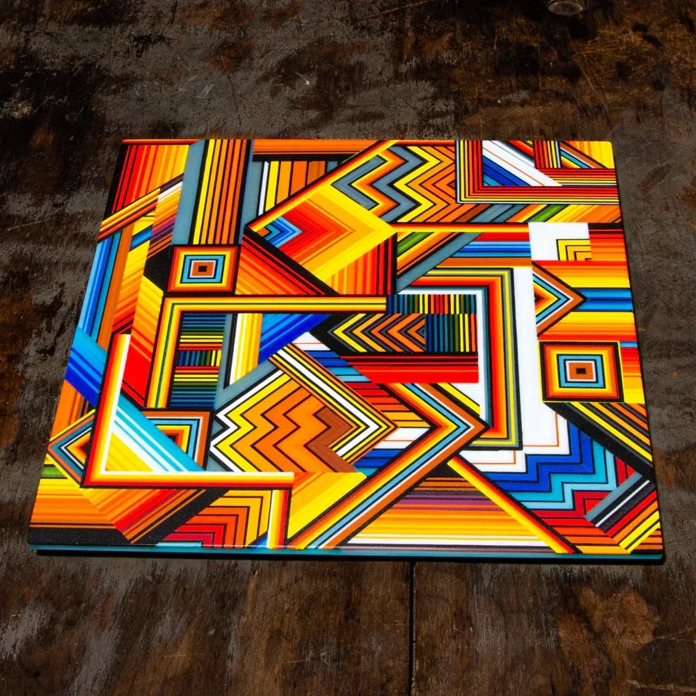 Colorful geometric abstract art panel with zigzag and linear patterns on a wood surface