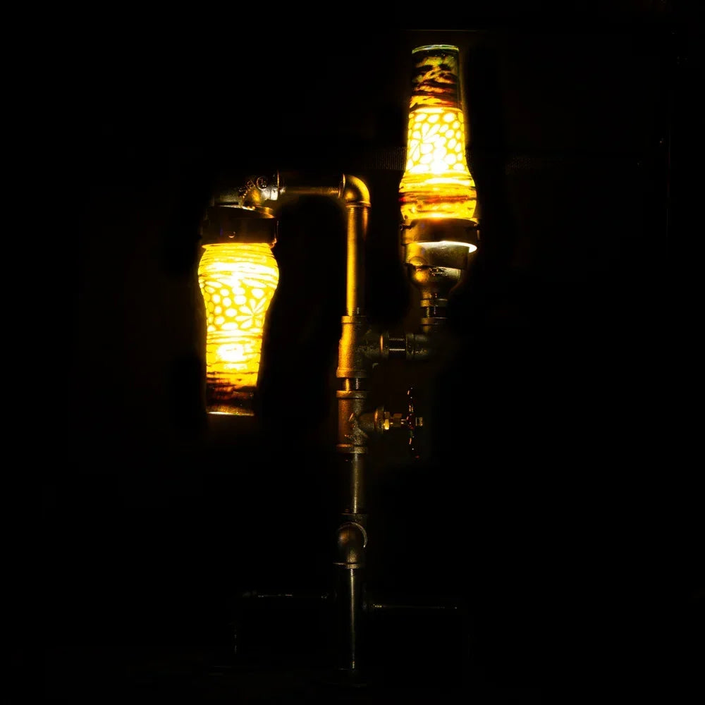 Artistic heady glass water pipe with glowing yellow details and industrial metal joints