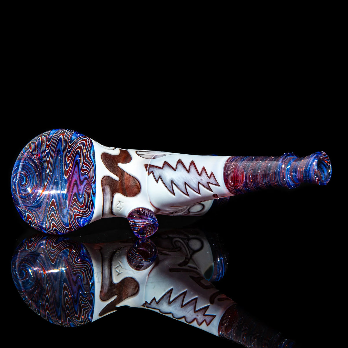 Heady glass hand pipe with colorful swirl patterns and zigzag design on black background