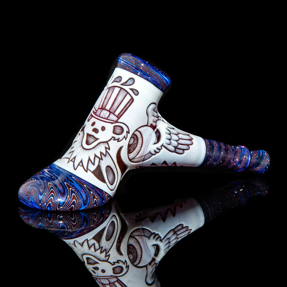 Heady glass pipe with blue swirls and detailed bear and winged eye designs on white background