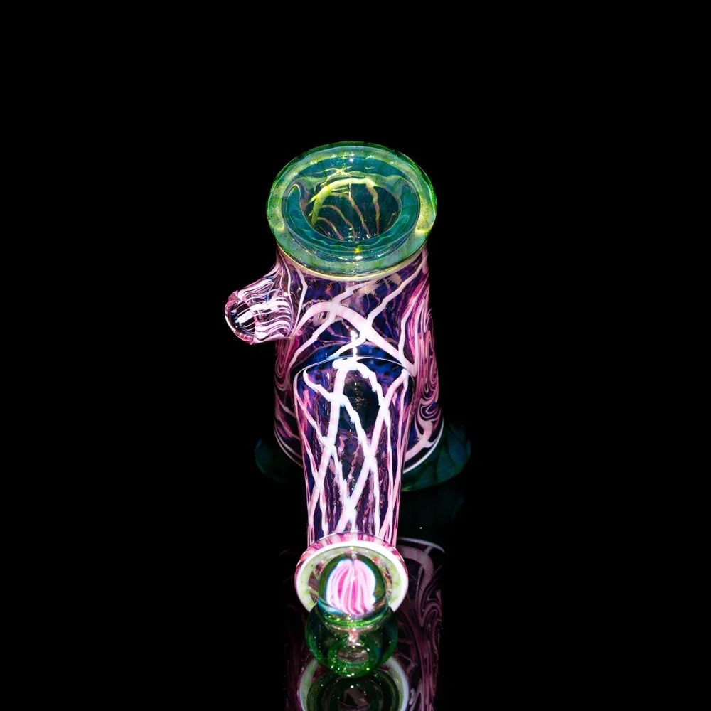 Colorful glass water pipe with twisted pink and white designs on black background
