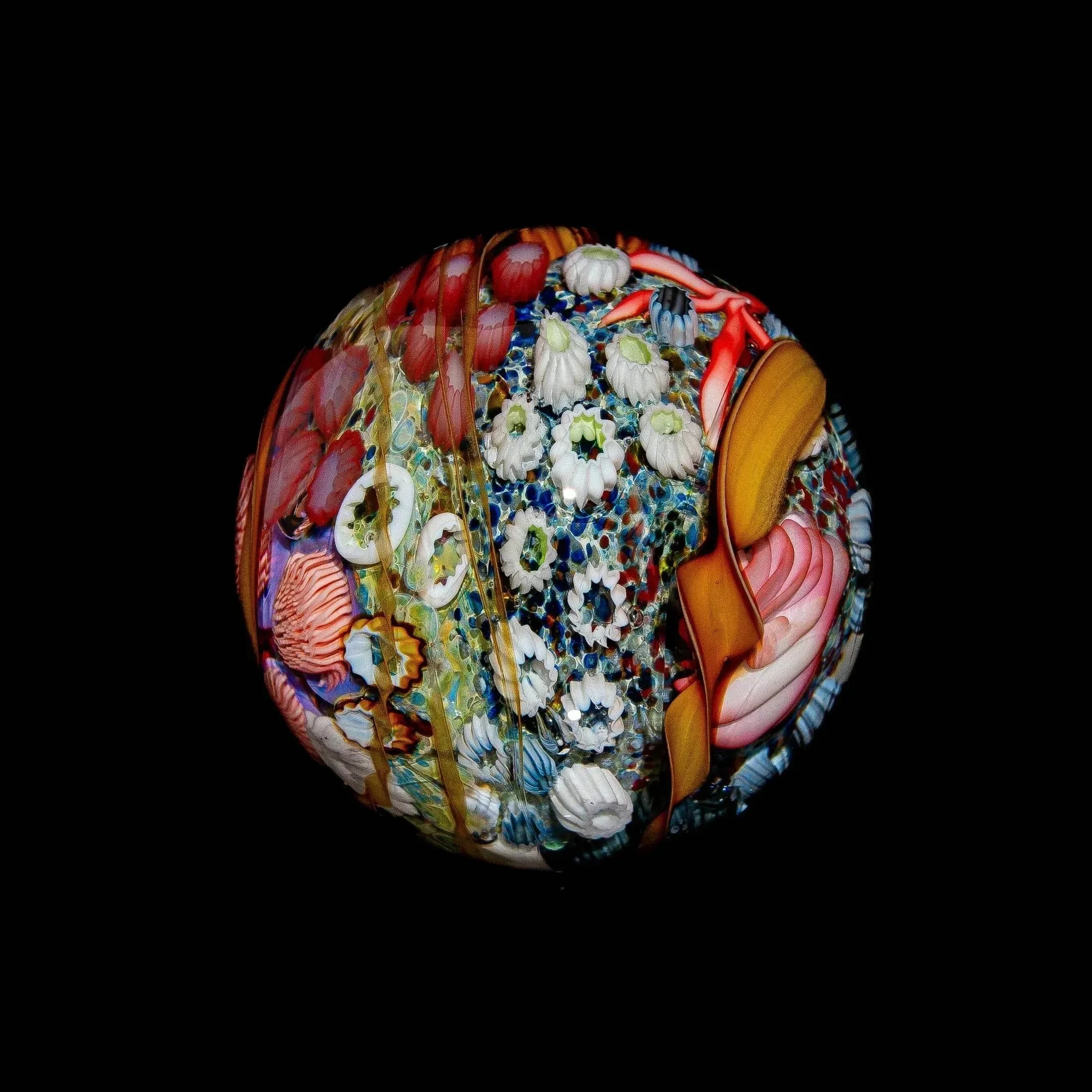 Colorful hand-blown glass art marble with intricate tide pool and floral designs