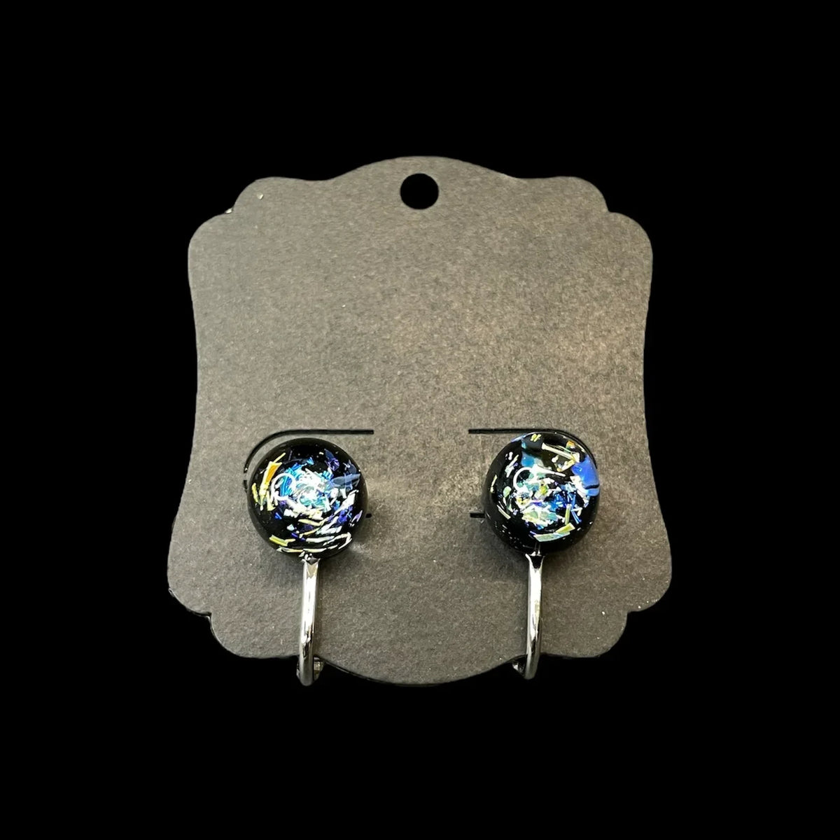 Handcrafted glass earrings with swirling blue, yellow, and white designs on black display card