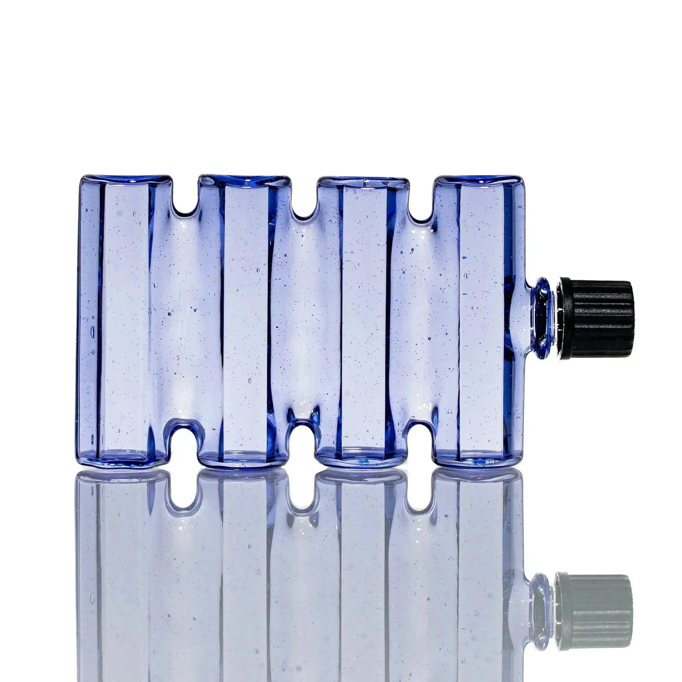 Blue rectangular glass drinking vessel with ridged design and black cap on white background