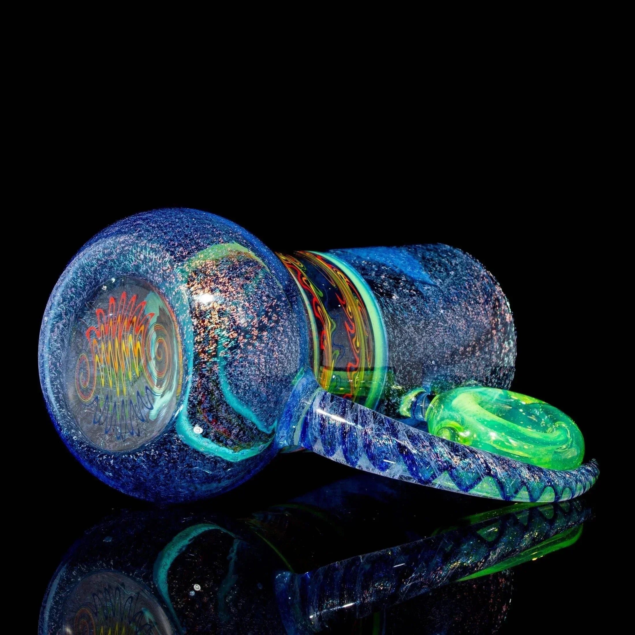 Colorful glass hand pipe with swirling blue, green, and iridescent patterns on black background