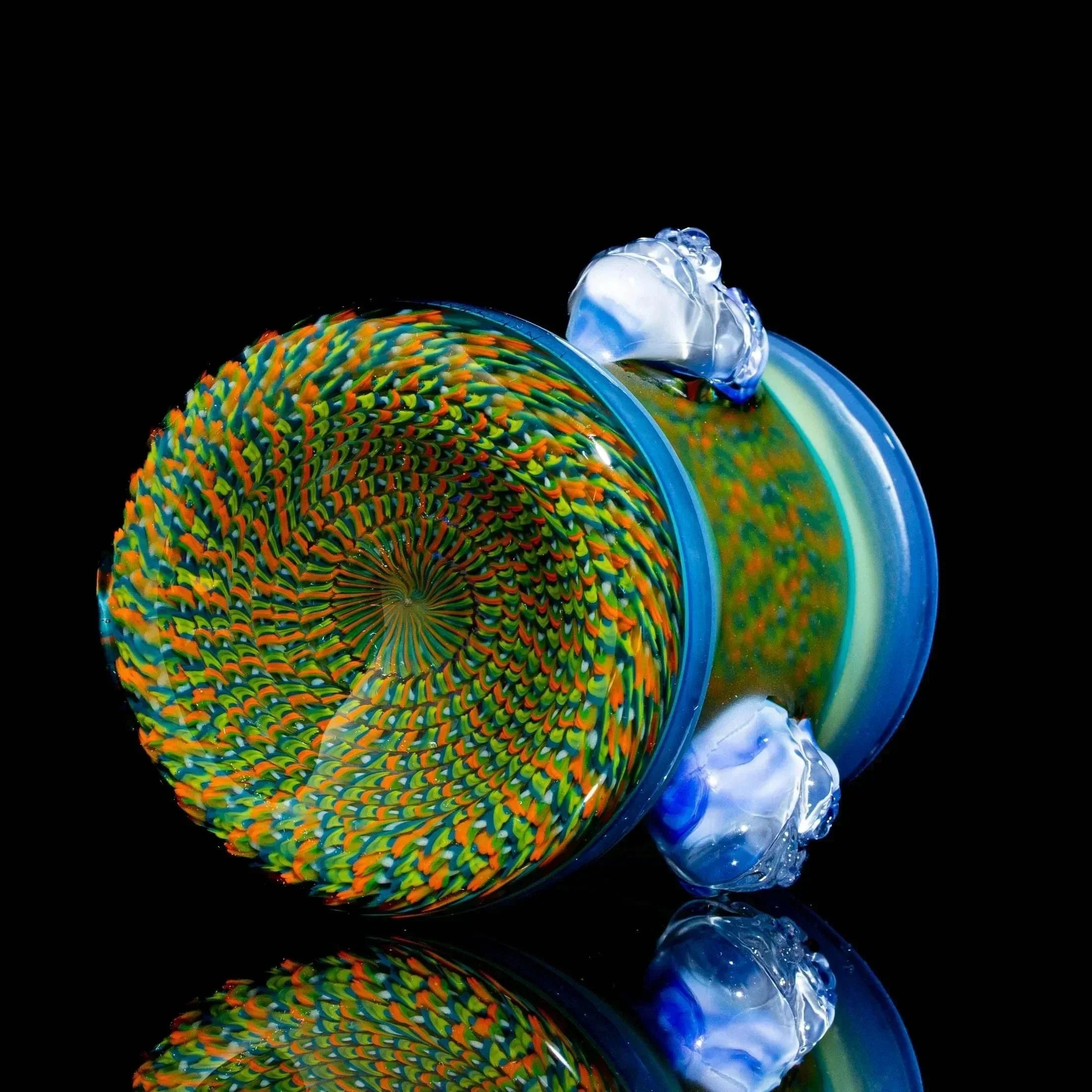 Colorful heady glass drinking vessel with intricate spiral pattern and blue accents on black background