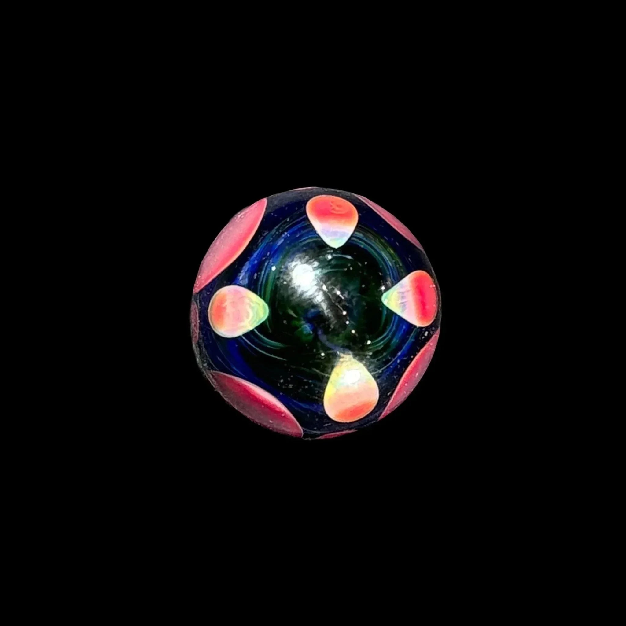 Colorful glass marble with vibrant red and yellow petal designs on a black background