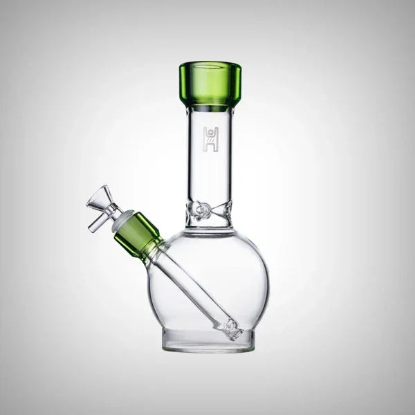 Clear glass water pipe with green accents and a round base on a white background