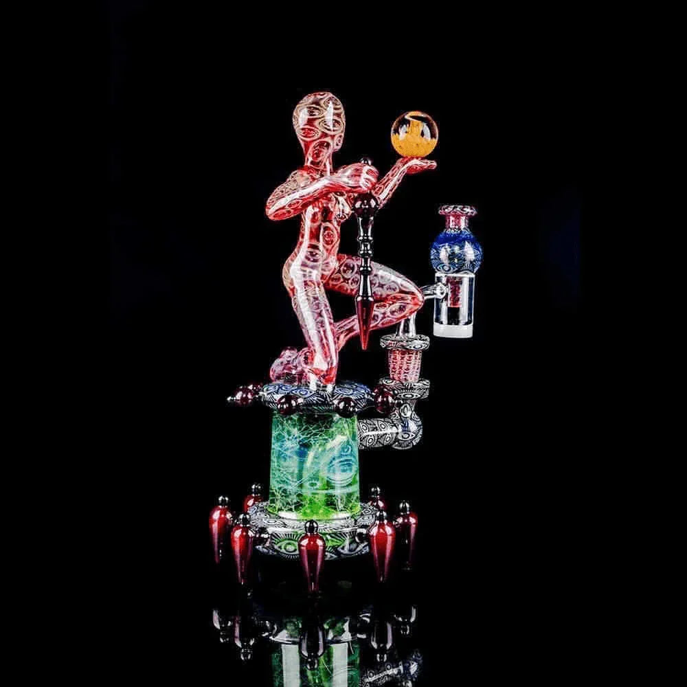 Heady glass water pipe featuring a red and clear humanoid figure with intricate designs