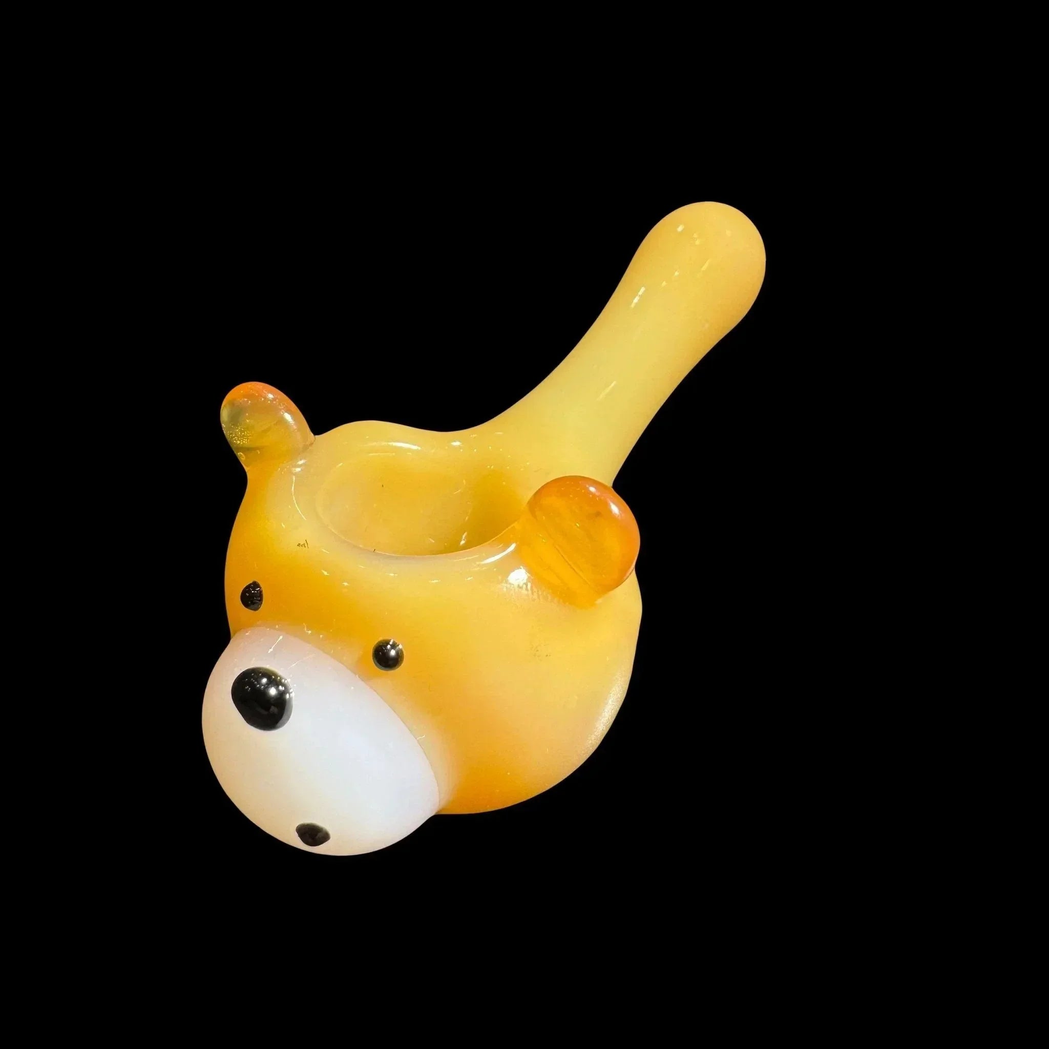 Yellow bear-shaped glass pipe with orange ears on black background