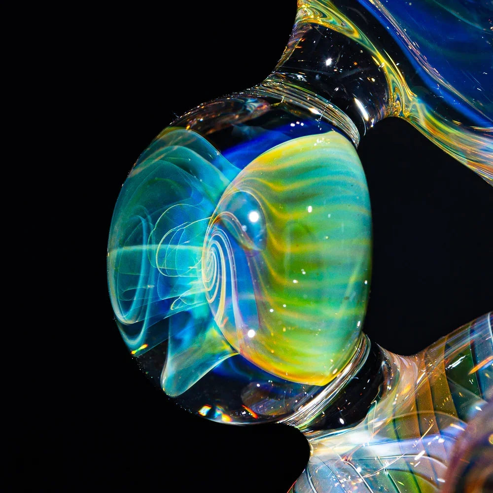 Close-up of colorful heady glass art with swirling fume details on a hand-blown water pipe