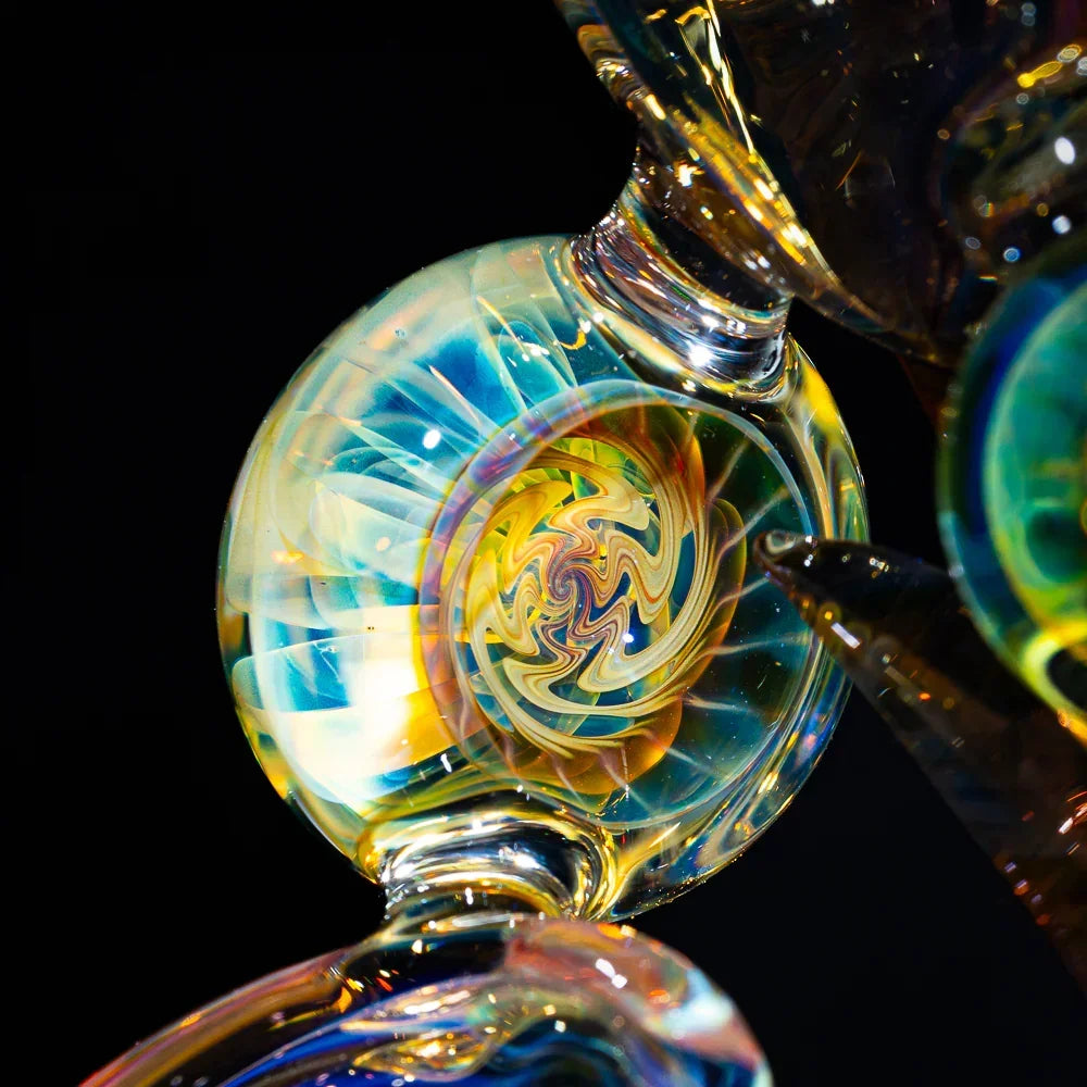 Close-up of intricate heady fumed glass art with swirling colors and reflective details