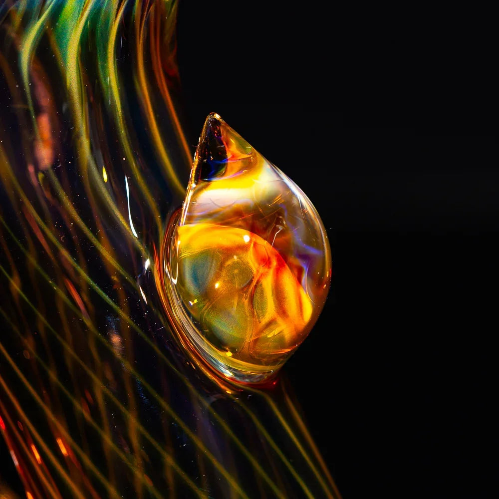 Close-up of honeycomb fumed glass pipe with vivid iridescent colors on black background.