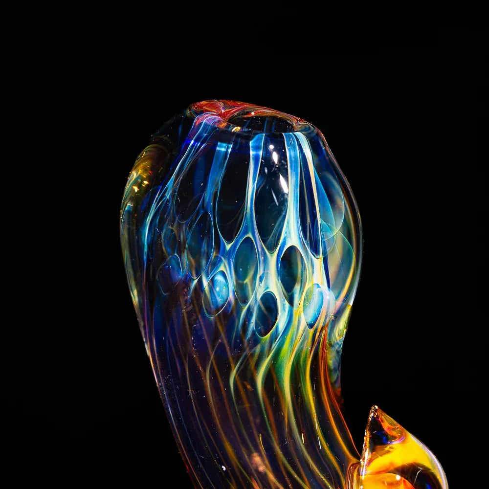 Colorful honeycomb fume glass pipe with intricate patterns on a black background