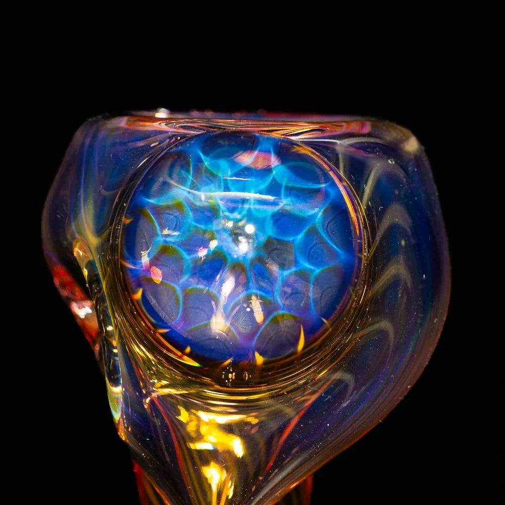 Close-up of a honeycomb fume glass pipe with blue and gold iridescent details