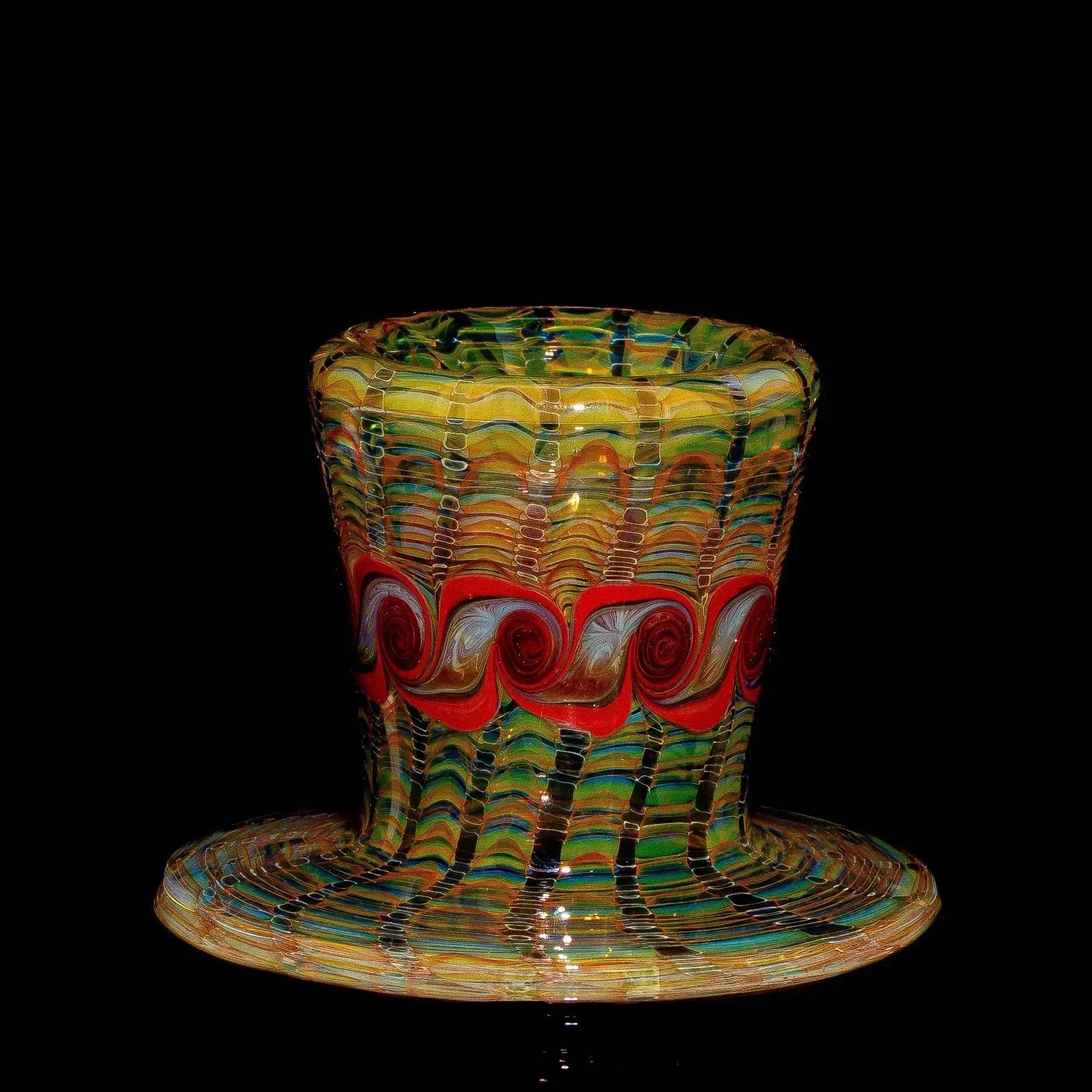 Heady glass marble stand with vibrant bronze, red, and green swirled patterns on black background