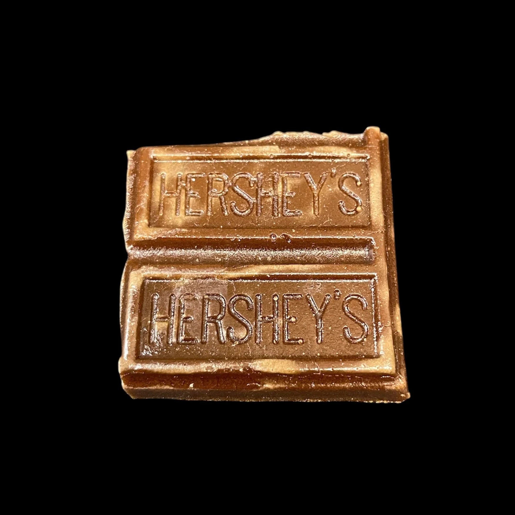 Small Hershey's chocolate bar piece with two sections on a black background
