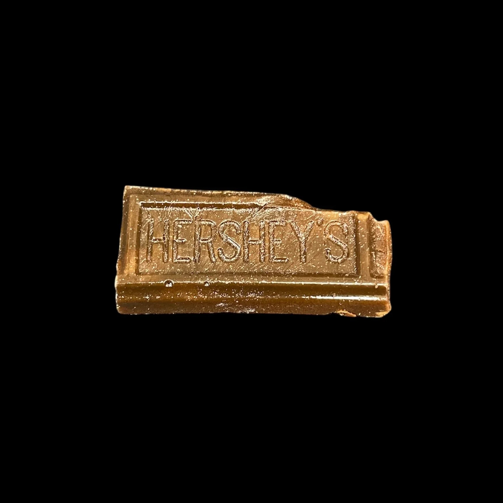 Small Hershey's chocolate bar piece on black background, close-up view