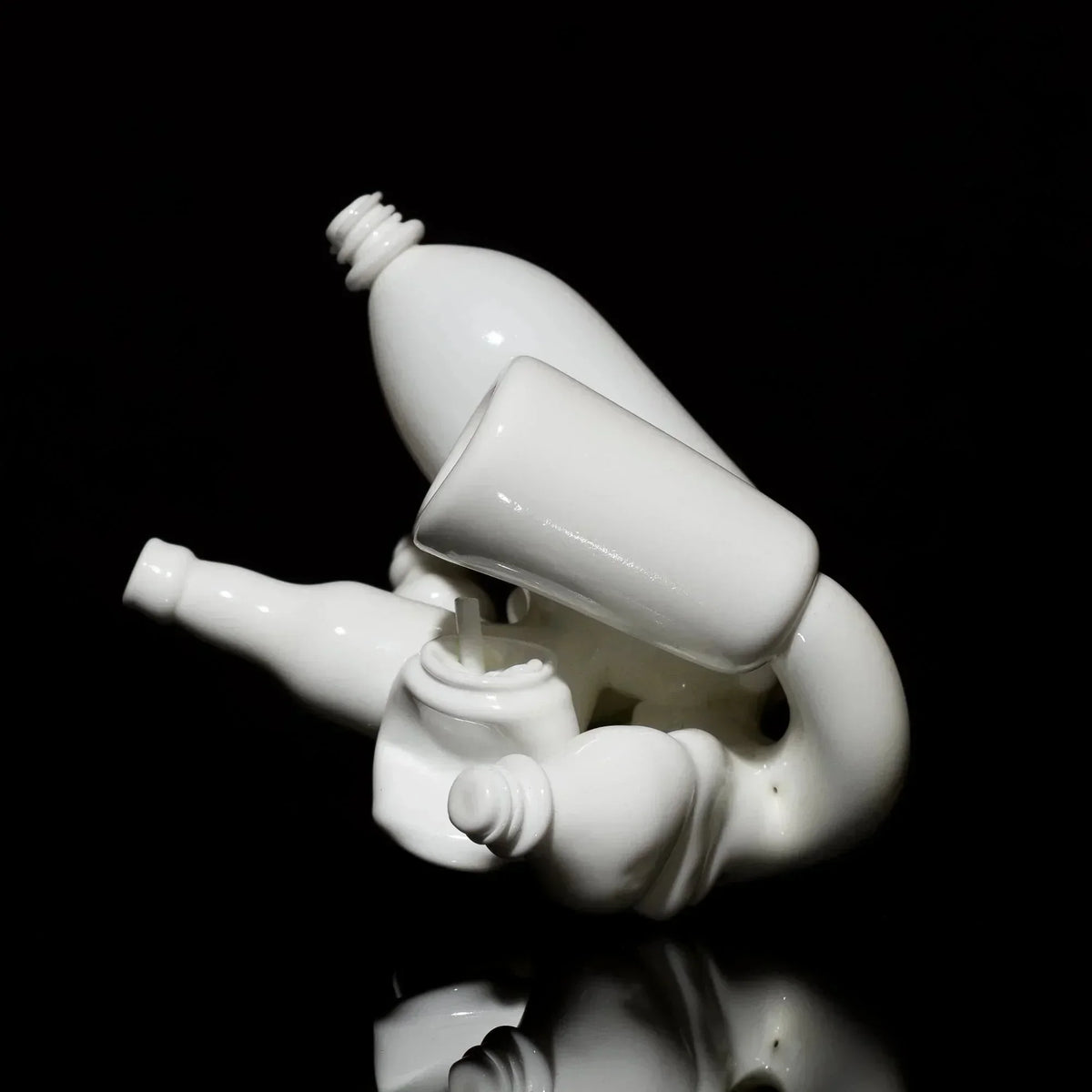 Abstract white glass art sculpture with bottle shapes on black background