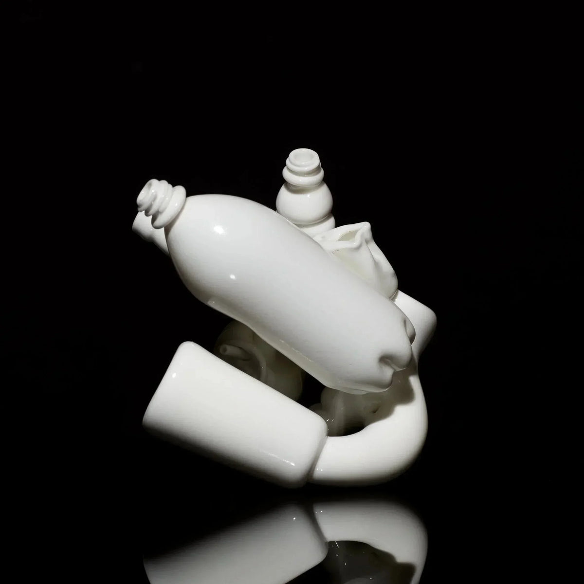 Sculptural white glass art piece with abstract, intertwined shapes on a black background.