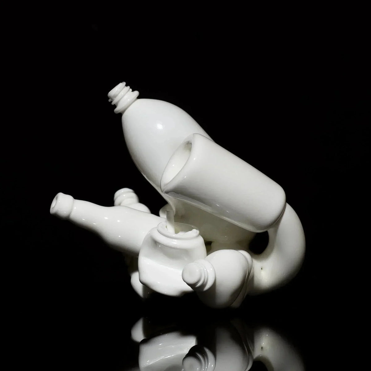 White sculpted glass art pipe with bottle shapes on black background