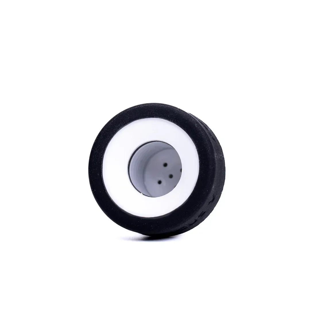 Ceramic vaporizer chamber with black silicone exterior and airflow holes on white background