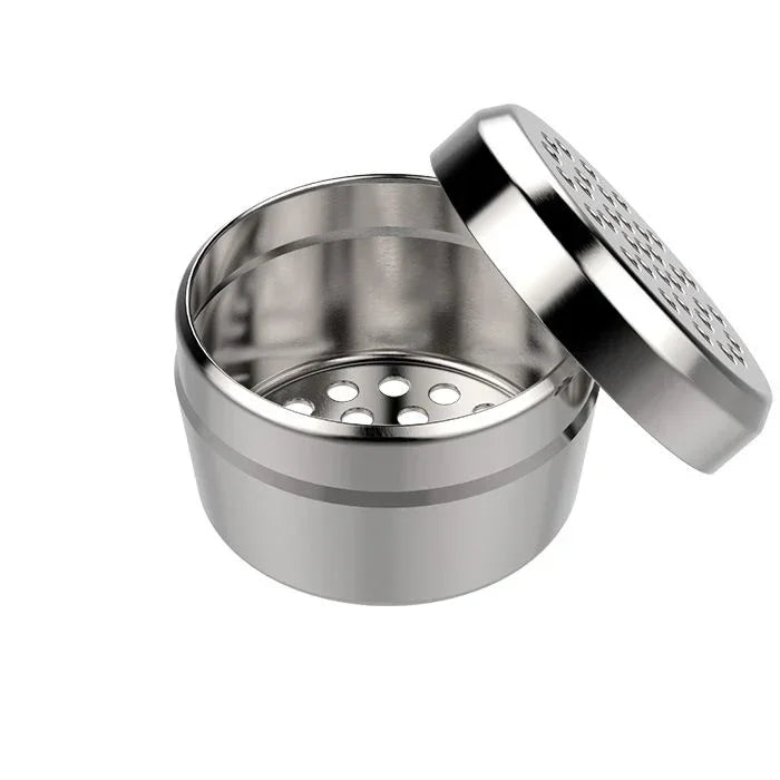Stainless steel herb grinder with open lid and laser-cut holes, ideal for grinding herbs.