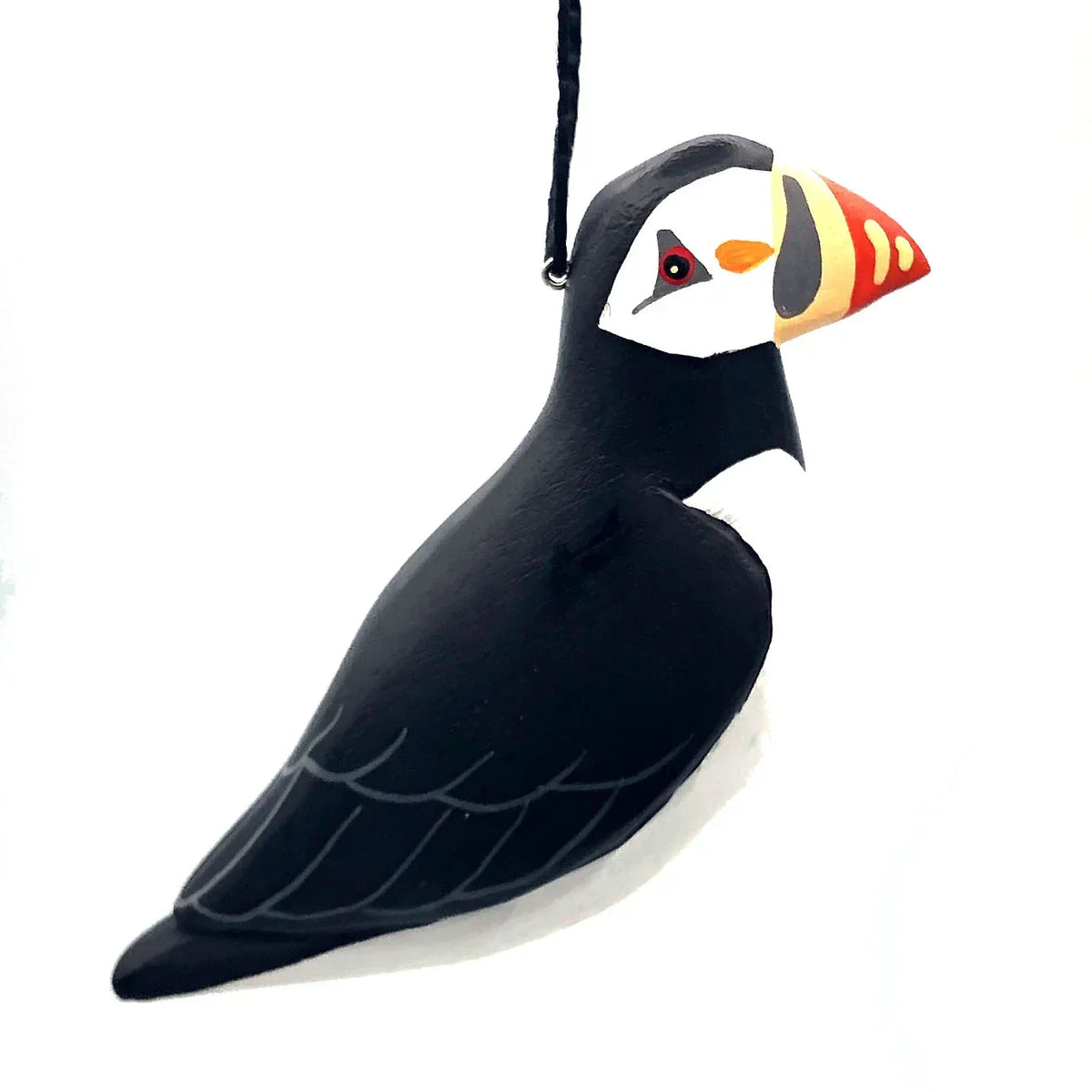 Hand-painted puffin bird ornament with black, white, and orange details, hanging on string.