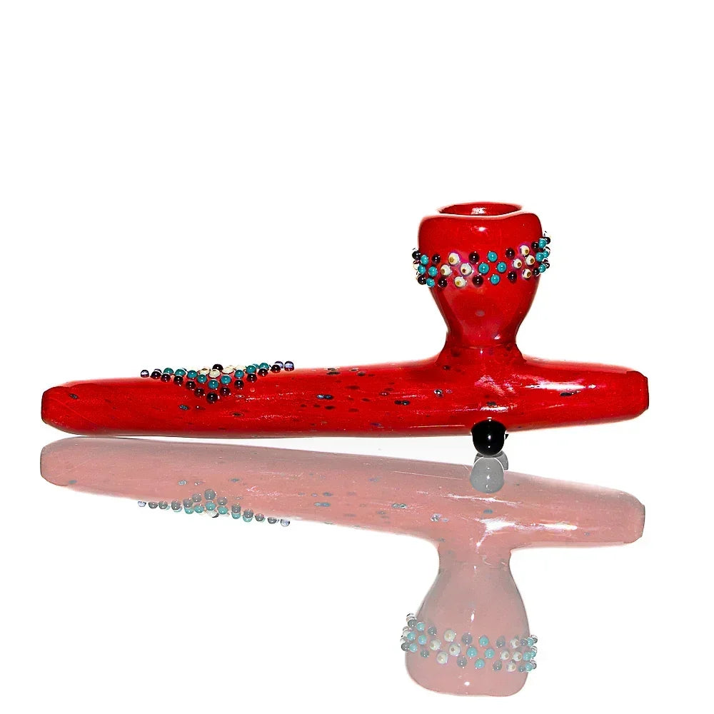 Red glass pipe with decorative multicolor beads, artistically designed and photographed on white background.