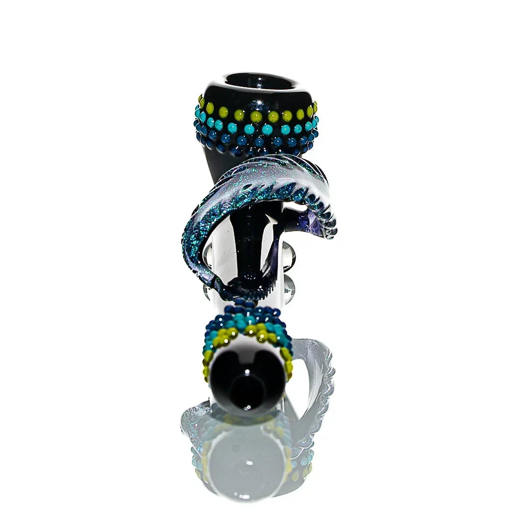 Hand-blown glass pipe with blue and green dotted accents, feather-shaped detail, on white backdrop