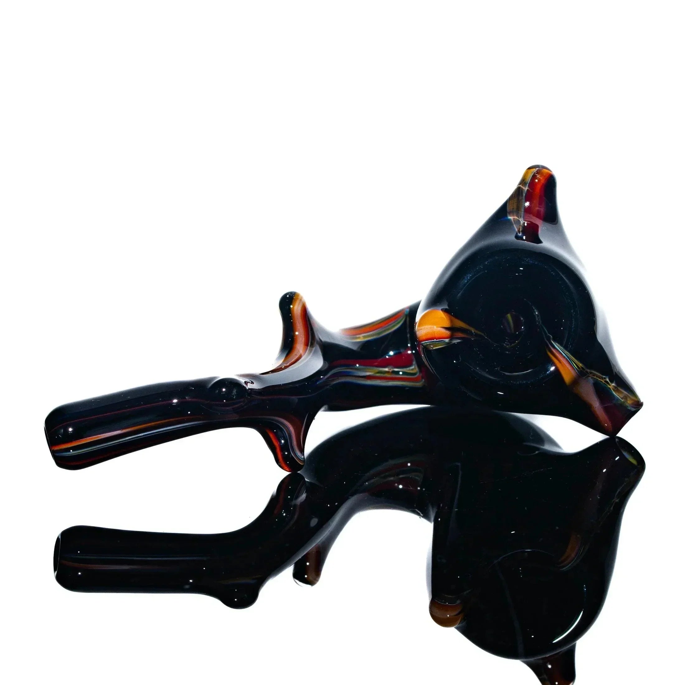 Hand-blown glass sherlock pipe with black, orange, and red accents on a reflective surface