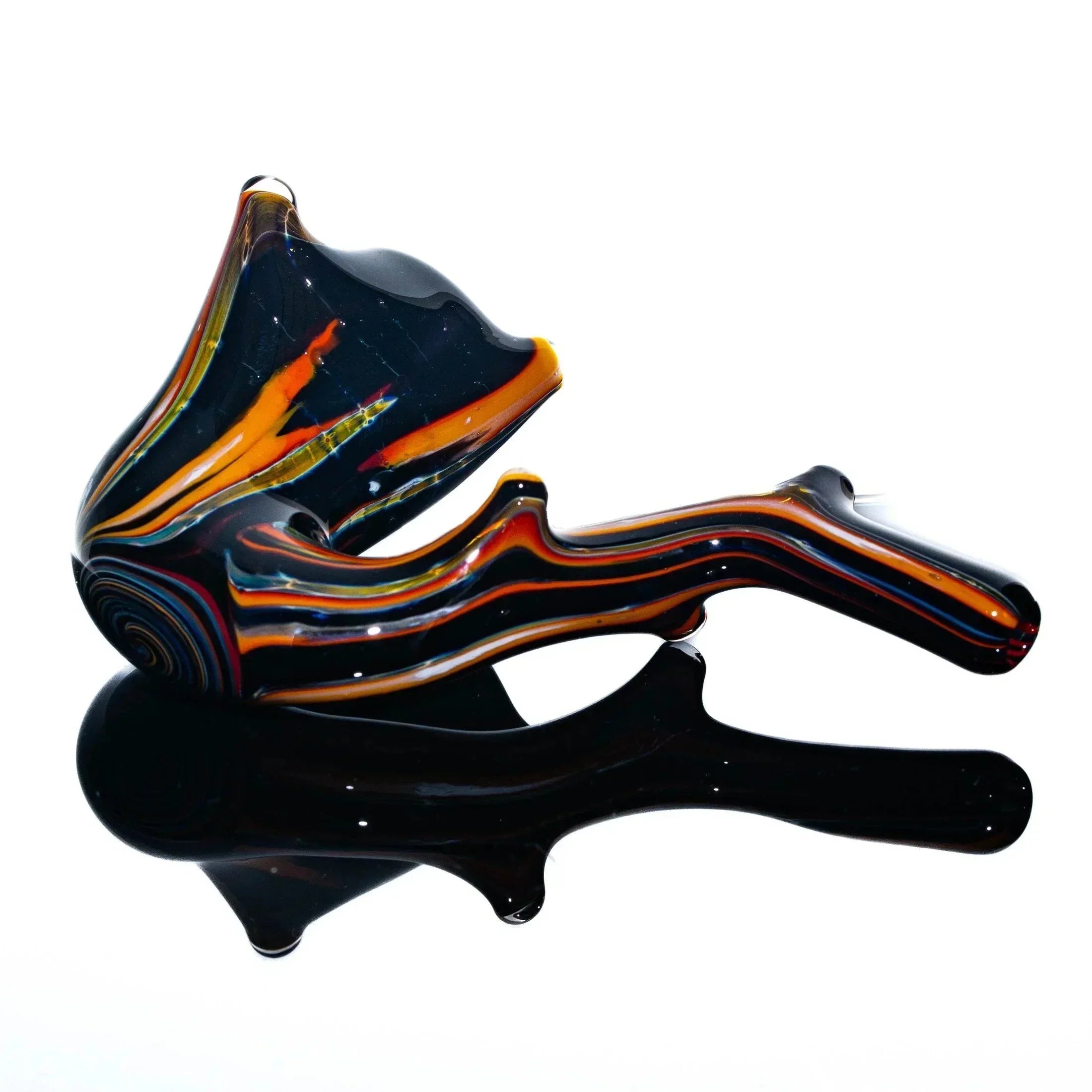 Colorful hand-blown glass Sherlock pipe with orange and black swirls on a reflective surface