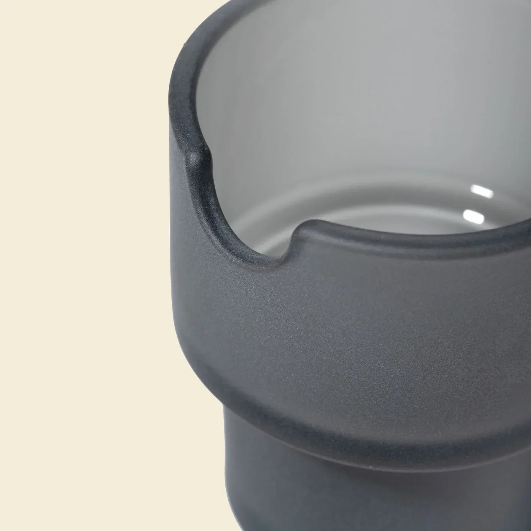 Close-up of a matte charcoal glass bowl with a spout, modern smoke shop accessory