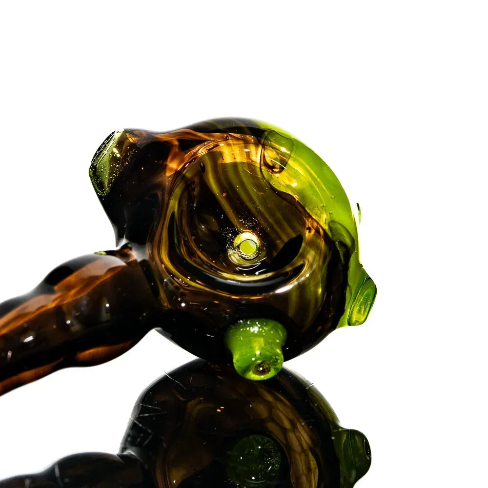 Black and green glass honeycomb spoon pipe with reflective surface on white background