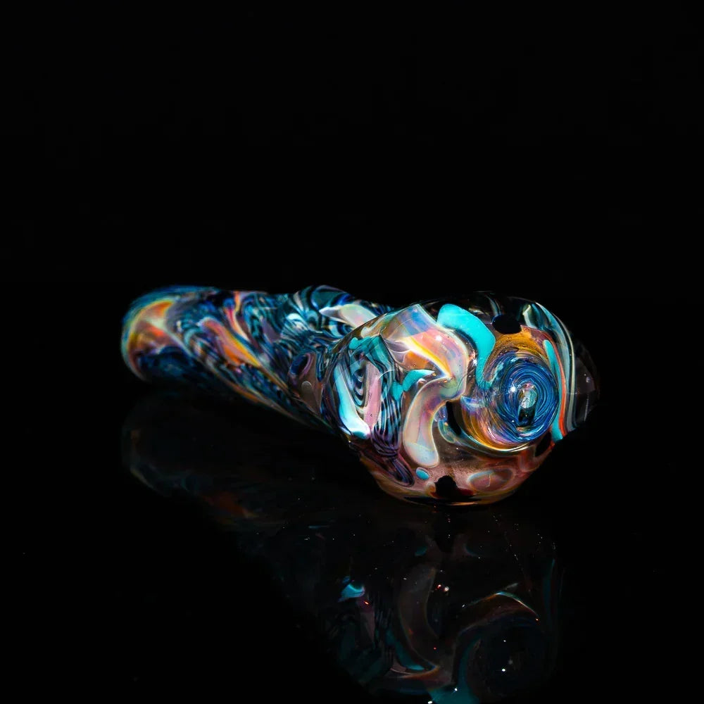 Colorful fumed glass spoon pipe with inside-out swirl design on black background