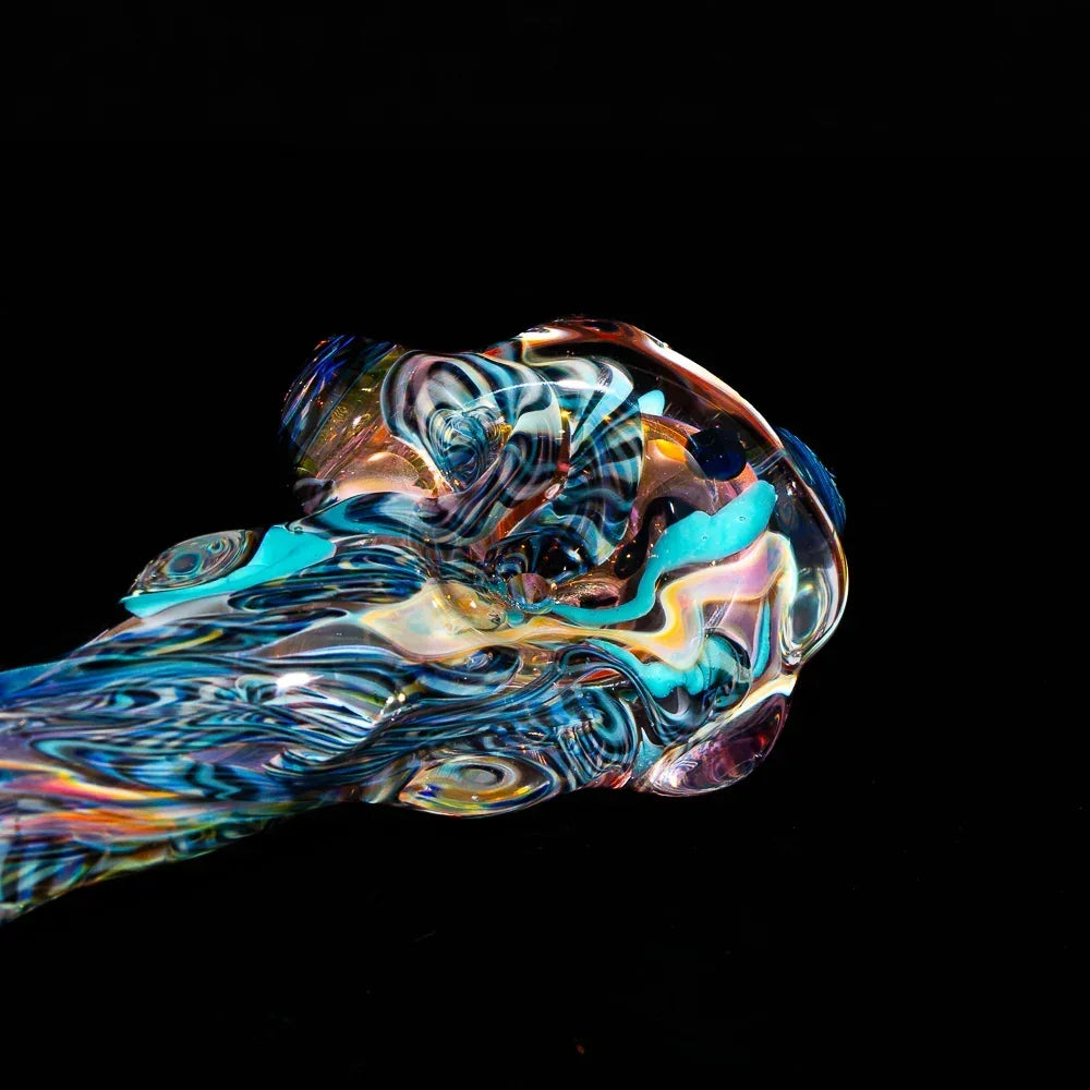 Hand-blown inside-out glass spoon pipe with colorful fumed patterns on black background