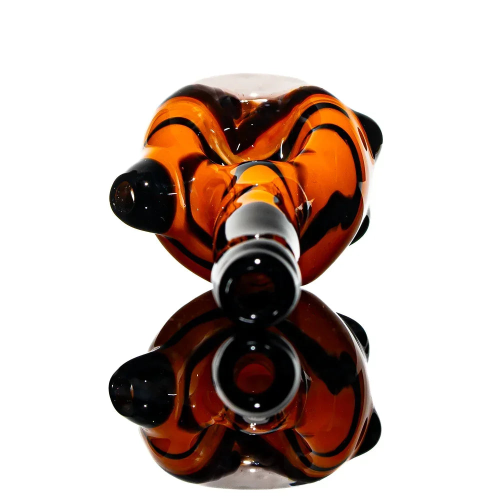 Hand-blown glass spoon pipe with orange and black swirled design on white background