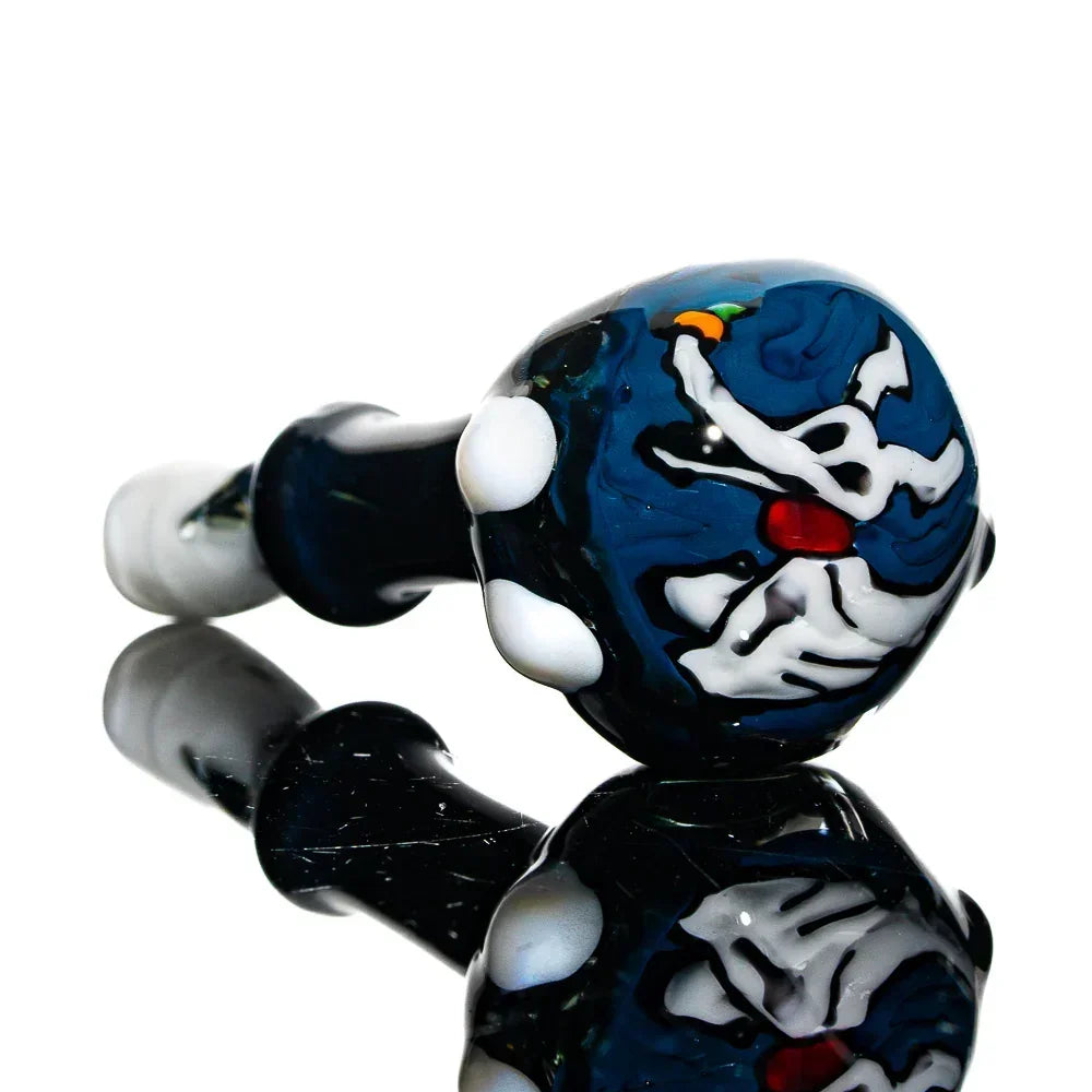 Hand-blown glass pipe with artistic dog design and vibrant colors, reflected on black surface