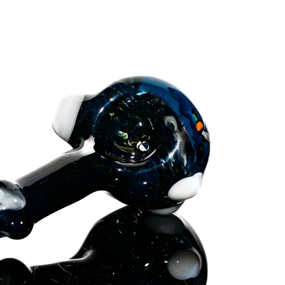 Handcrafted glass spoon pipe shaped like a dog with dark colors and white accents