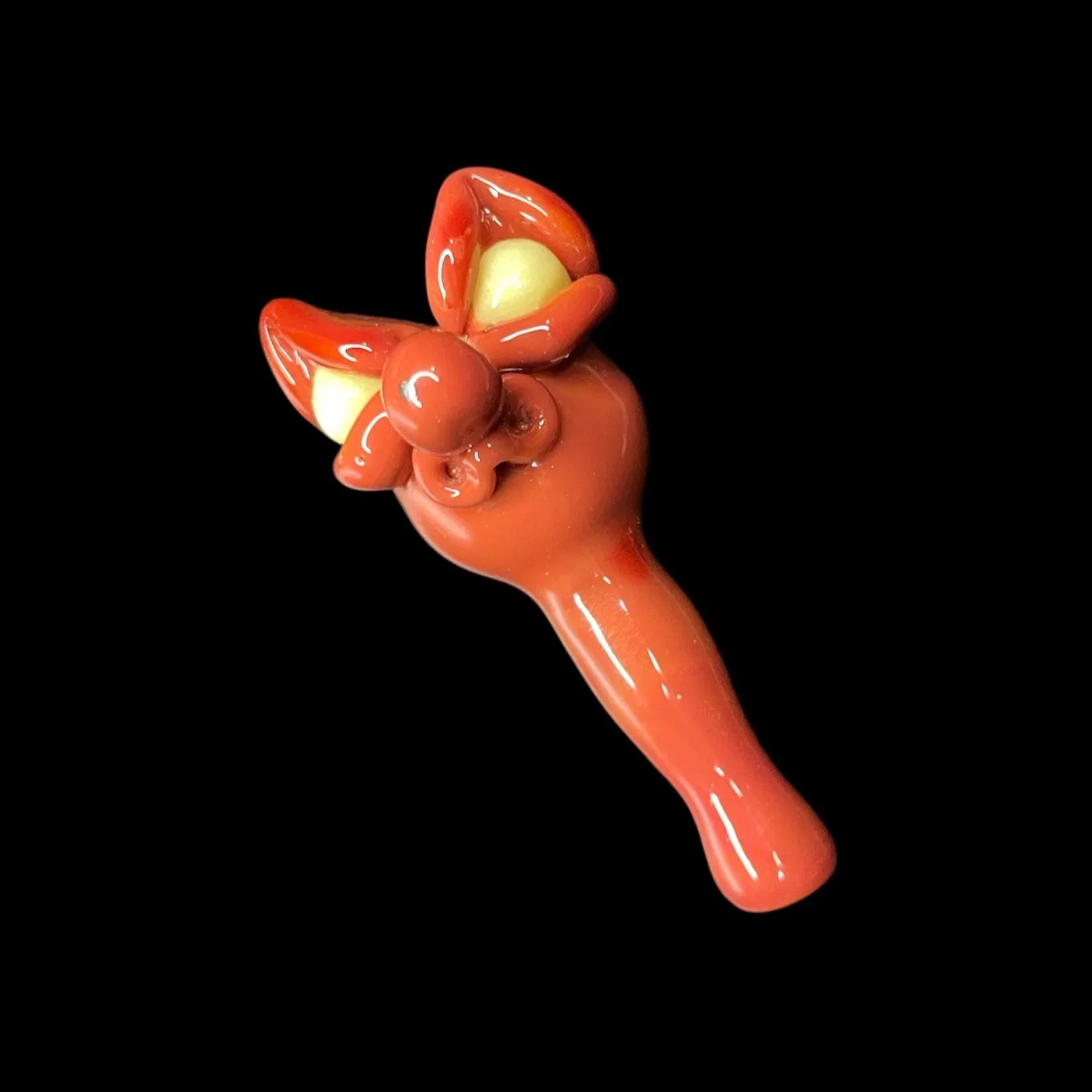 Orange glass joystick cap with sculpted decorative accents on black background