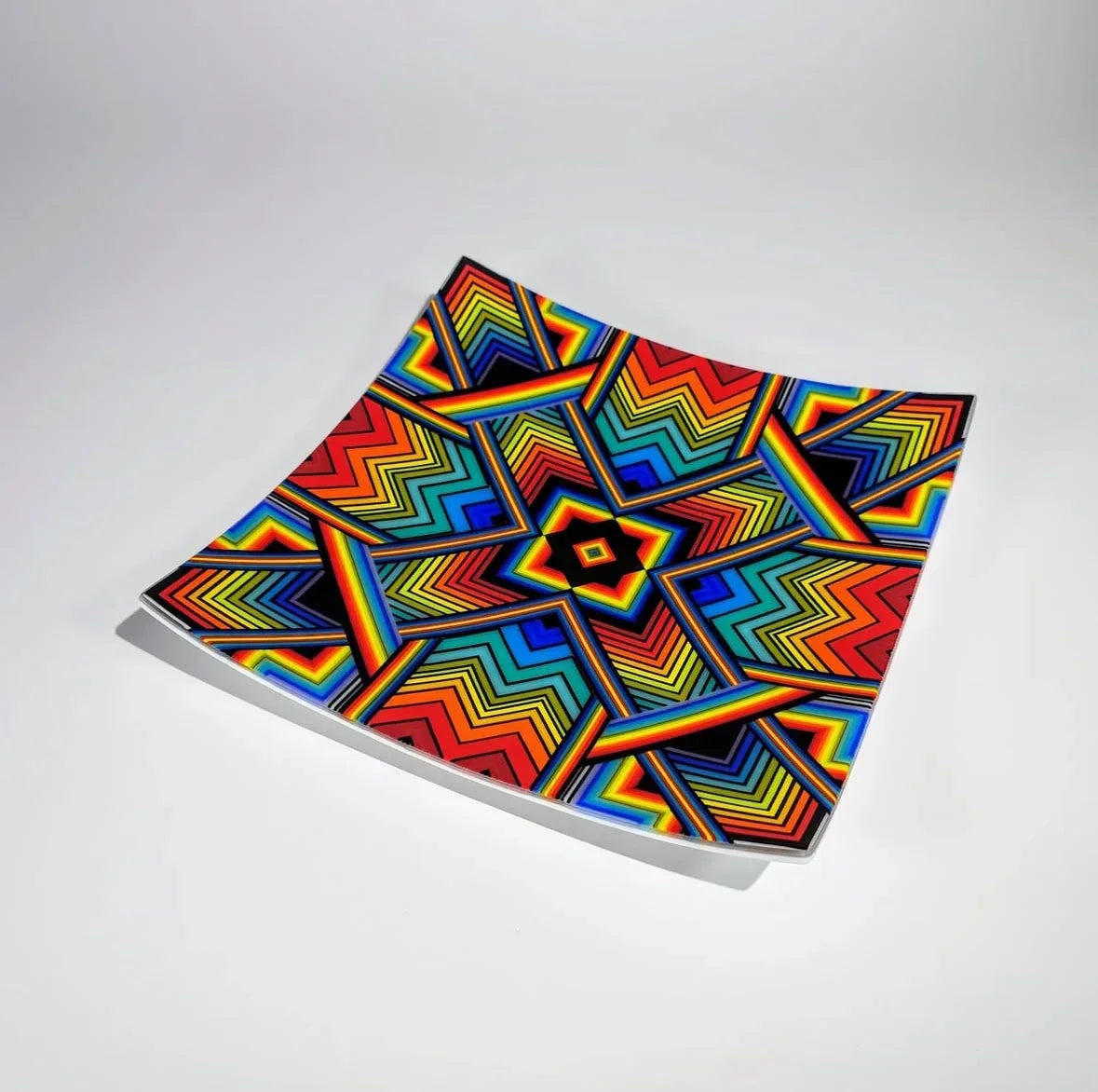Colorful glass tray with geometric rainbow chevron pattern on white background
