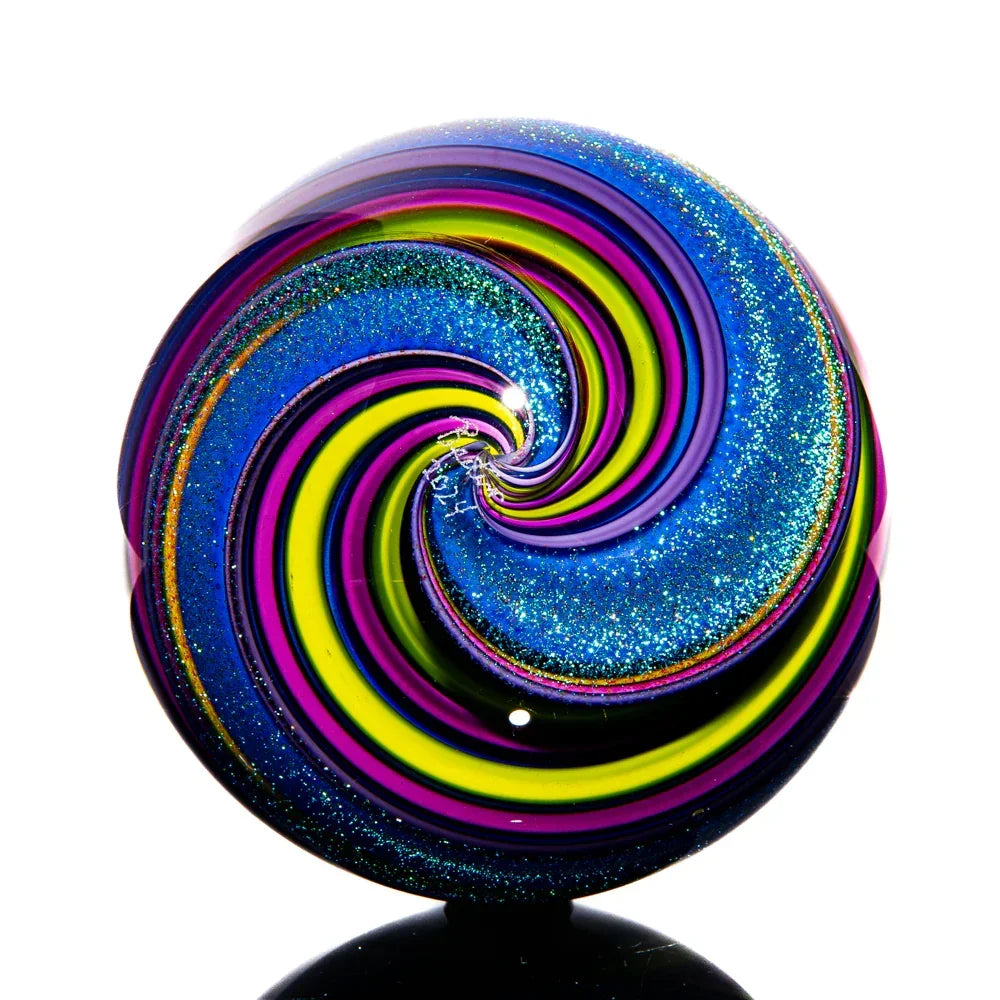 Colorful glass marble with blue, yellow, green, and purple spiral pattern and glitter accents